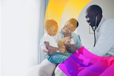 African American doctor using a stethoscope on a young boy sitting in their mother's lap.