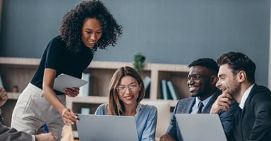 Colleagues collaborating around a laptop