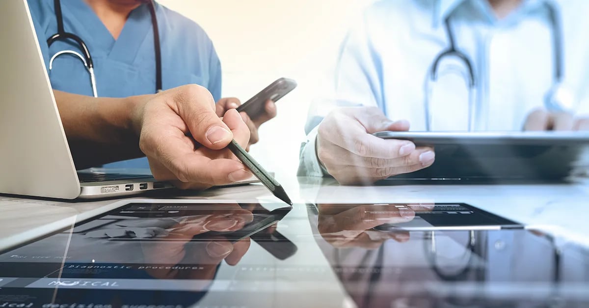 Person holding pen pointing to tablet device on a table