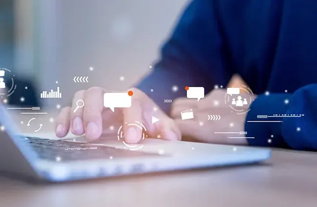 Person using a laptop with internet icons floating