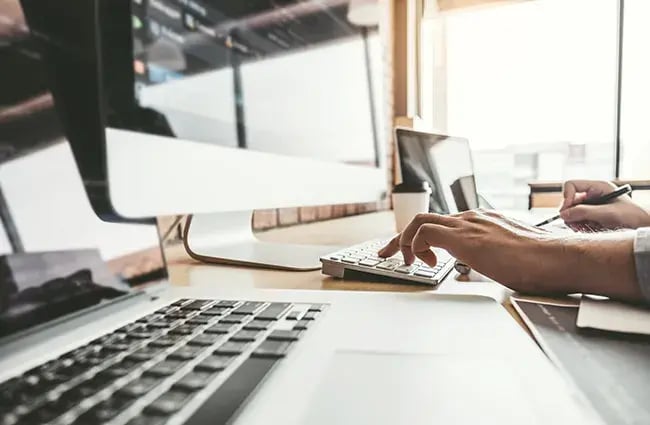 Person working on desktop and laptop devices