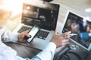 professional-looking-at-two-monitors-with-data-and-graphs