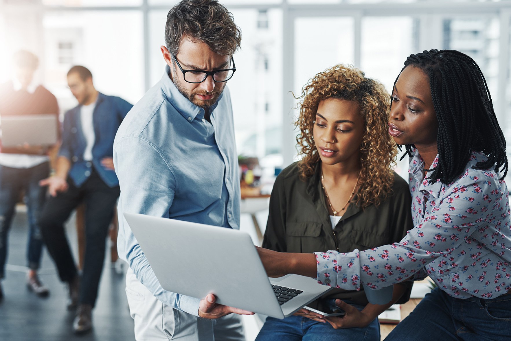 professionals-pointing-to-laptop-as-914178358