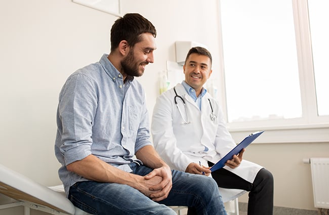 Smiling doctor young man meeting exam-room