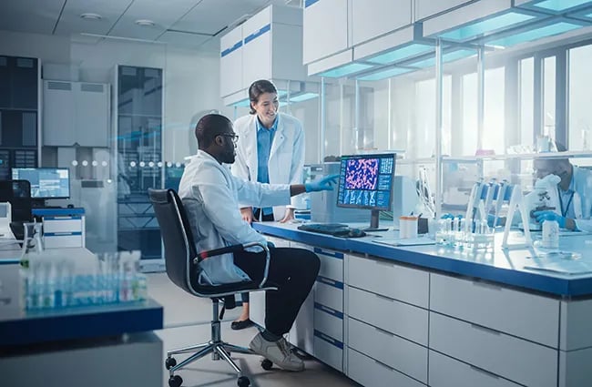 Two technicians working together in a lab at a computer