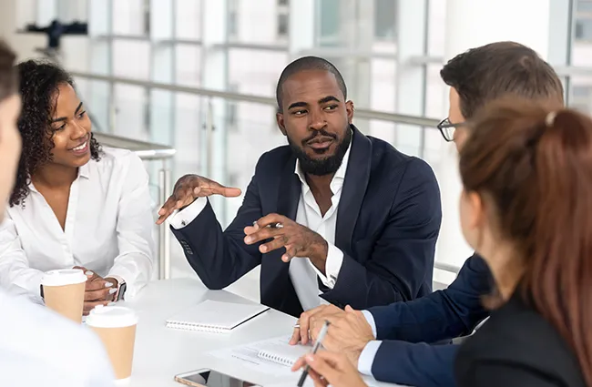 Group of professionals drinking coffee talking at a table